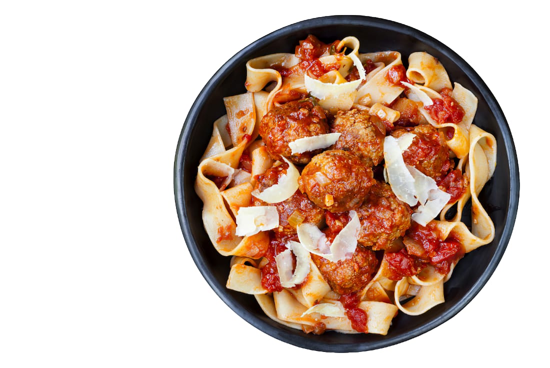 Fettuccine noodles and meat balls in a black bowl